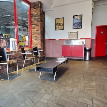 The waiting area at Meriden Quick Lube: seating, a low table, and a window onto the service bay.